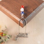 Taurus zodiac necklace displayed on wooden board with lapis lazuli, clear quartz, and red agate.