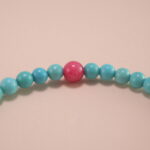 Close-up of turquoise and rhodochrosite bracelet with silver.