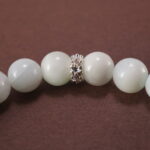 Close-up of white chalcedony and lepidolite bracelet.