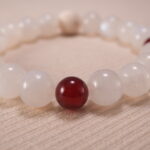 Close-up of white chalcedony and red agate bracelet with lava stone.