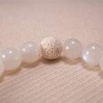 Close-up of white chalcedony and red agate bracelet with lava stone.