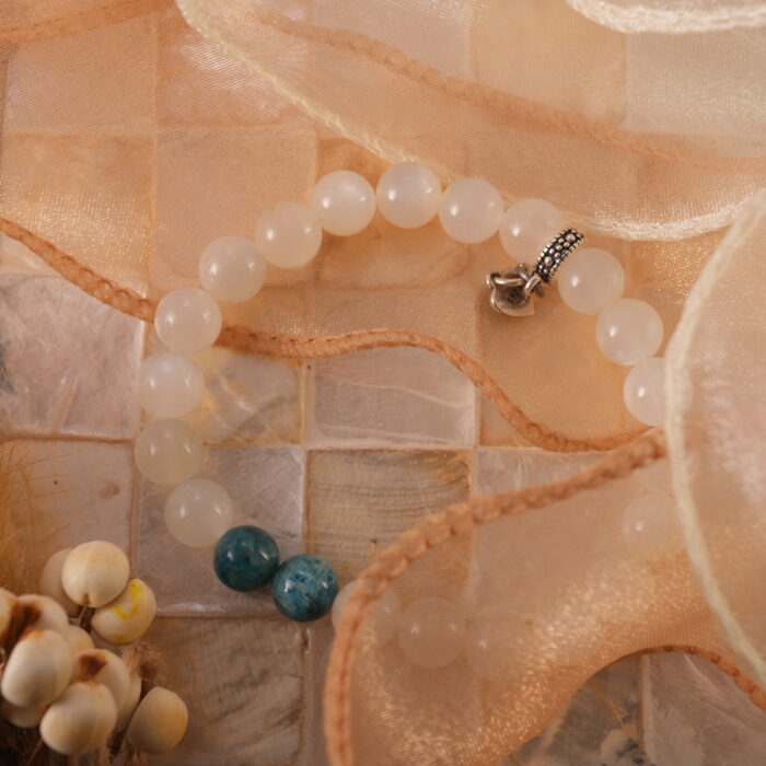 White moonstone and apatite bracelet in natural light with soft glow.