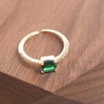 Close-up of the emerald’s natural texture and the open ring design with fine silverwork.