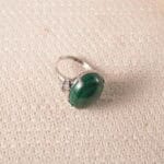 Adjustable open malachite ring displayed on a neutral background, showcasing its rich green hues and sleek silver band.