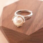 Close-up view of the lustrous pearl and polished silver band, showing the fine texture and adjustable open-end.