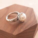 Close-up view of the lustrous pearl and polished silver band, showing the fine texture and adjustable open-end.