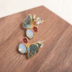 Close-up of the opal butterfly studs highlighting the shimmering finish and fine contours.
