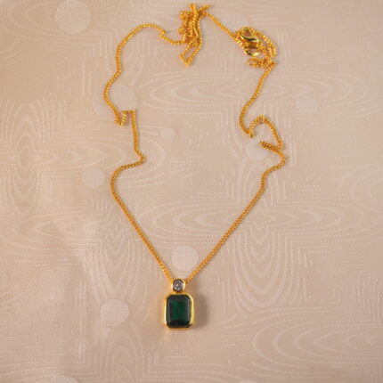 Emerald pendant necklace on white background