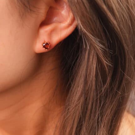 Model wearing the garnet heart studs, adding a soft and romantic touch.