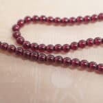 Close-up of polished garnet round beads on necklace