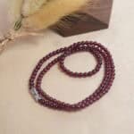 Model wearing garnet round bead necklace