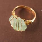 Handmade green fluorite wire-wrapped ring displayed on a neutral background.