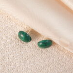 A pair of minimalist round malachite stud earrings featuring rich green patterns and natural luster.