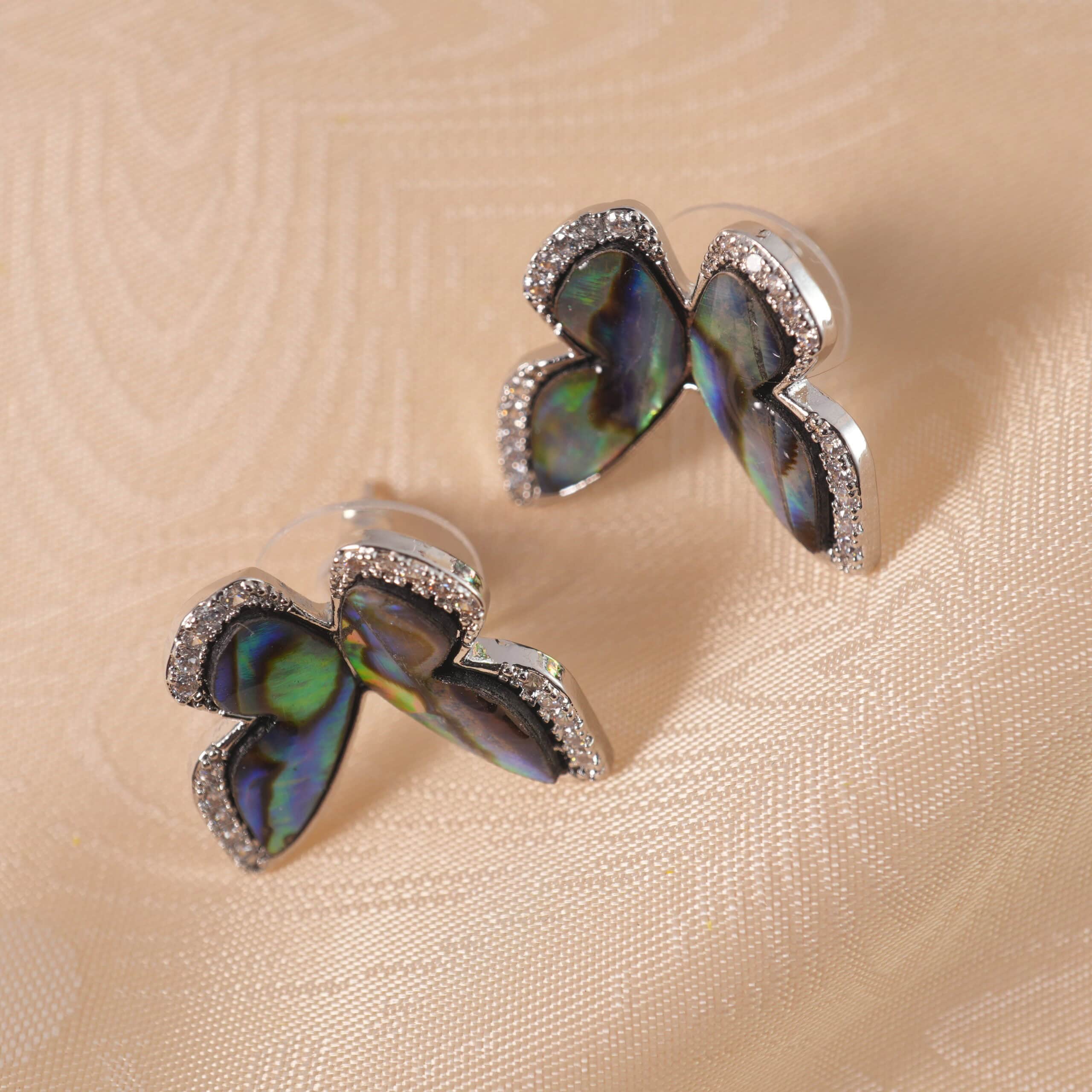 moonstone-butterfly-stud-earring-main A pair of butterfly-shaped moonstone stud earrings on a white background, displaying a soft iridescent glow.