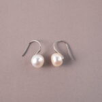 A pair of natural pearl stud earrings on a white background, showcasing their simple and elegant luster.