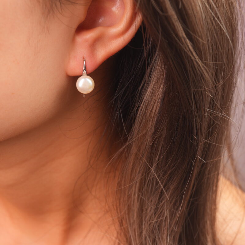 Model wearing the natural pearl stud earrings, showing a soft and elegant vibe by the ear.
