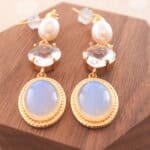 Close-up of the earrings, highlighting the opal’s iridescent hues and the natural luster of the pearls.