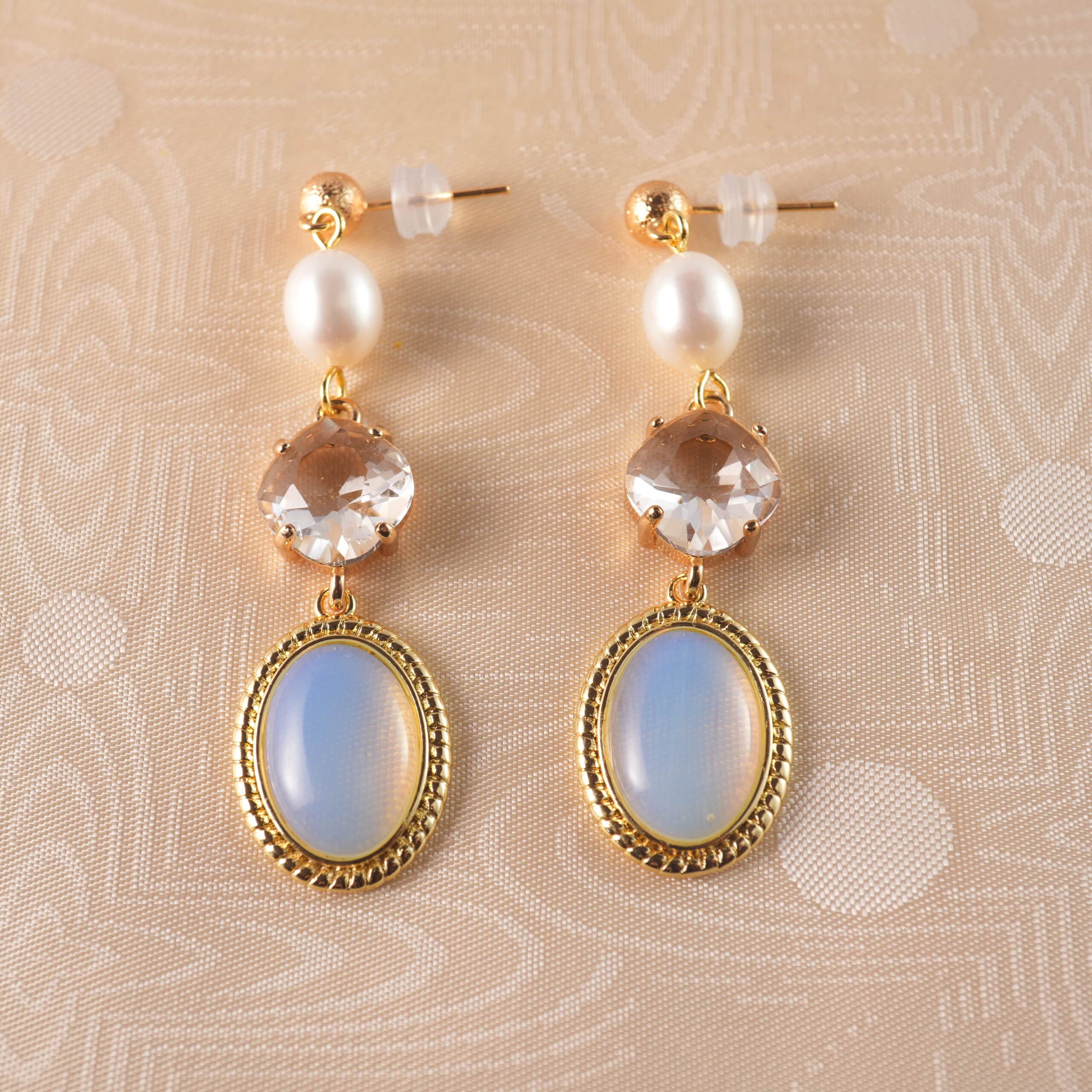 opal-pearl-drop-earring-main A pair of elegant opal and pearl drop earrings with a soft glow, set against a clean, minimal background.