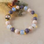 Opal and pink chalcedony bracelet placed on a minimalist background, surrounded by natural elements, creating a peaceful and harmonious vibe.