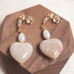 Close-up of the pearl earring, highlighting the lustrous pearl and fine metallic detailing.