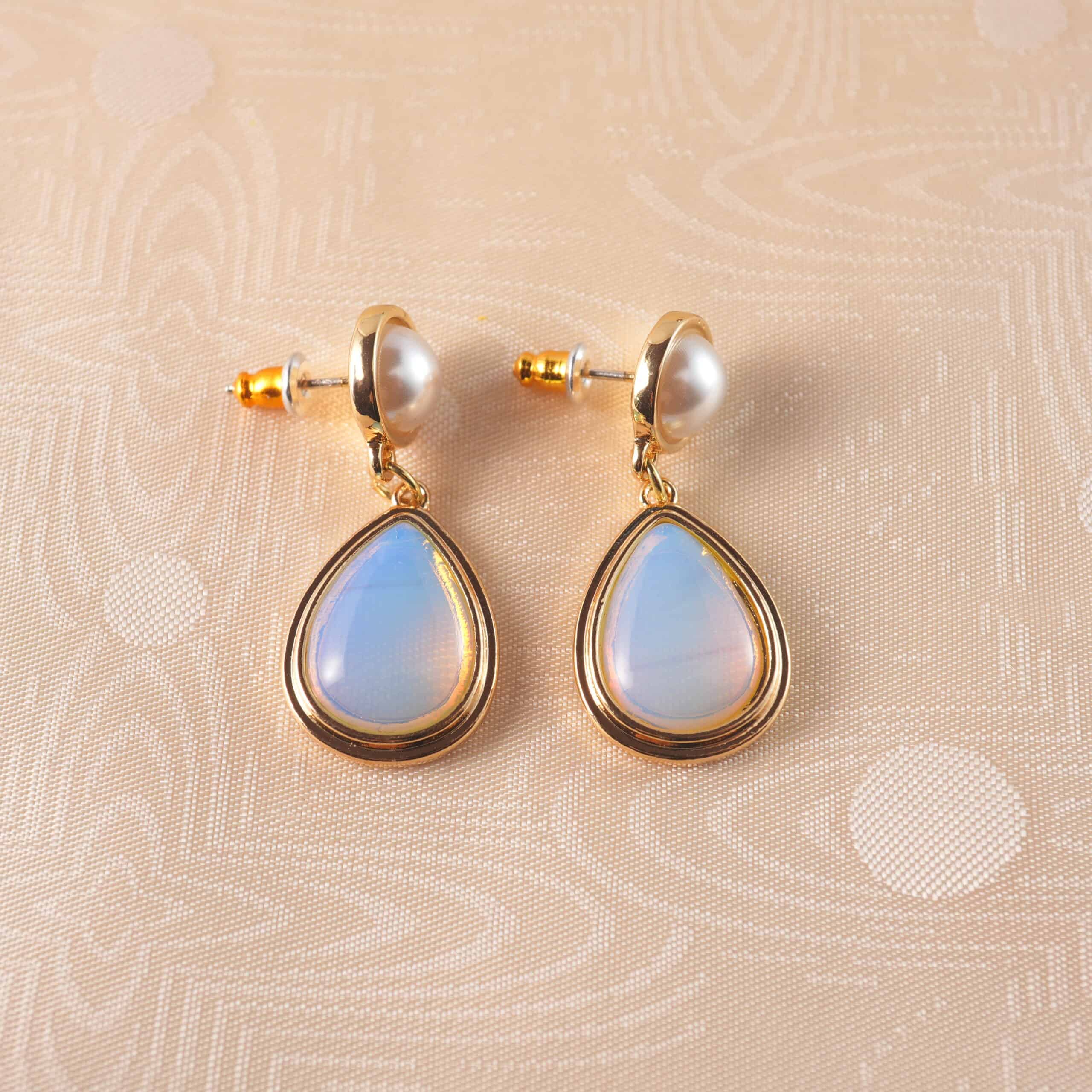 pearl-opal-teardrop-earring-main A pair of pearl and opal teardrop earrings with a delicate design, set against a clean, fresh background.