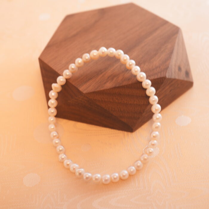 Close-up of the pearl stretch bracelet, showing the natural luster and fine texture of the beads.