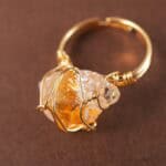 Close-up of the raw citrine and detailed wire wrapping, emphasizing its organic texture and golden hue.