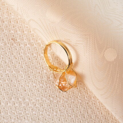 Raw citrine wire-wrapped ring displayed on a white background, showcasing its natural yellow crystal and handmade design.