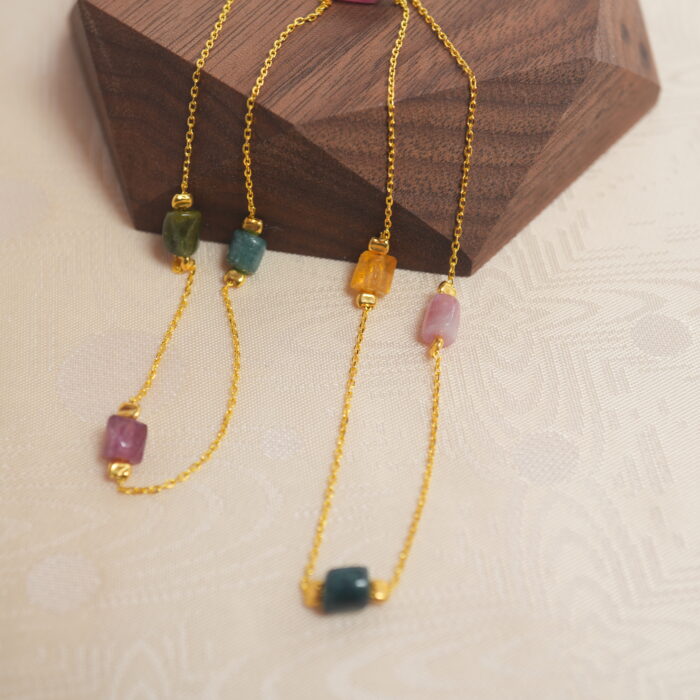 Tourmaline delicate necklace placed on wooden surface