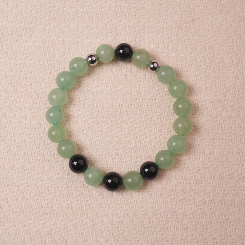 Green Aventurine and Obsidian bracelet, featuring smooth green aventurine beads and black obsidian beads, accented with silver spacers for an elegant design.