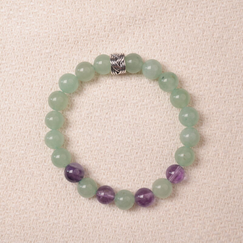 Prehnite and Amethyst bracelet featuring smooth prehnite and amethyst beads, with a silver spacer in the center for an elegant, calming design.