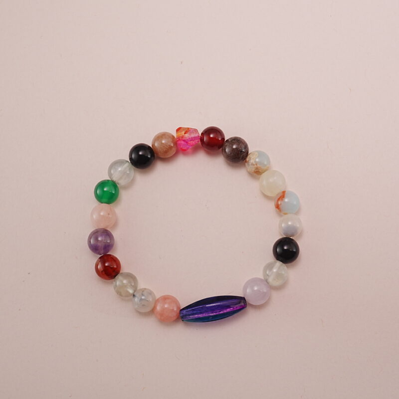 Multicolor crystal healing bracelet made with assorted gemstones, photographed under soft daylight on a neutral background.