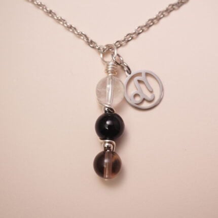 Capricorn zodiac necklace with clear quartz, obsidian, and smoky quartz gemstones.