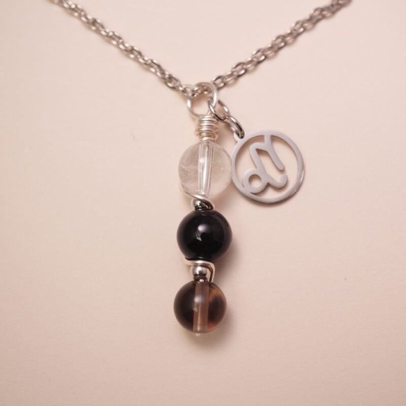 Capricorn zodiac necklace with clear quartz, obsidian, and smoky quartz gemstones.
