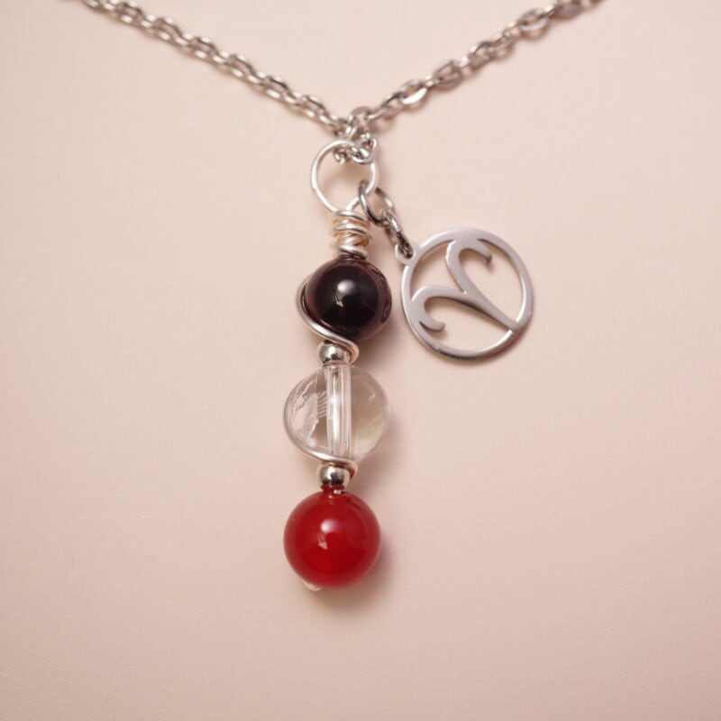 Aries zodiac necklace with amethyst, clear quartz, and red agate gemstones.