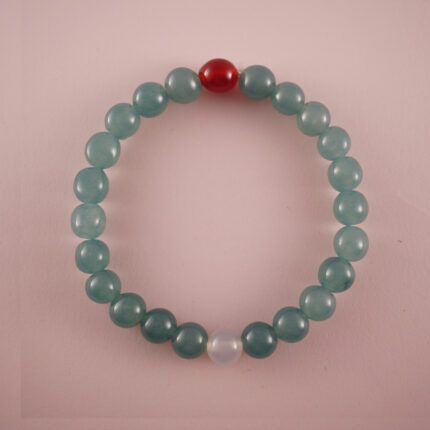 Green chalcedony bracelet with a red agate bead and a white chalcedony bead, photographed under soft daylight.