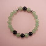 Green aventurine and black obsidian bracelet with silver accent beads, photographed under soft daylight on a neutral background.