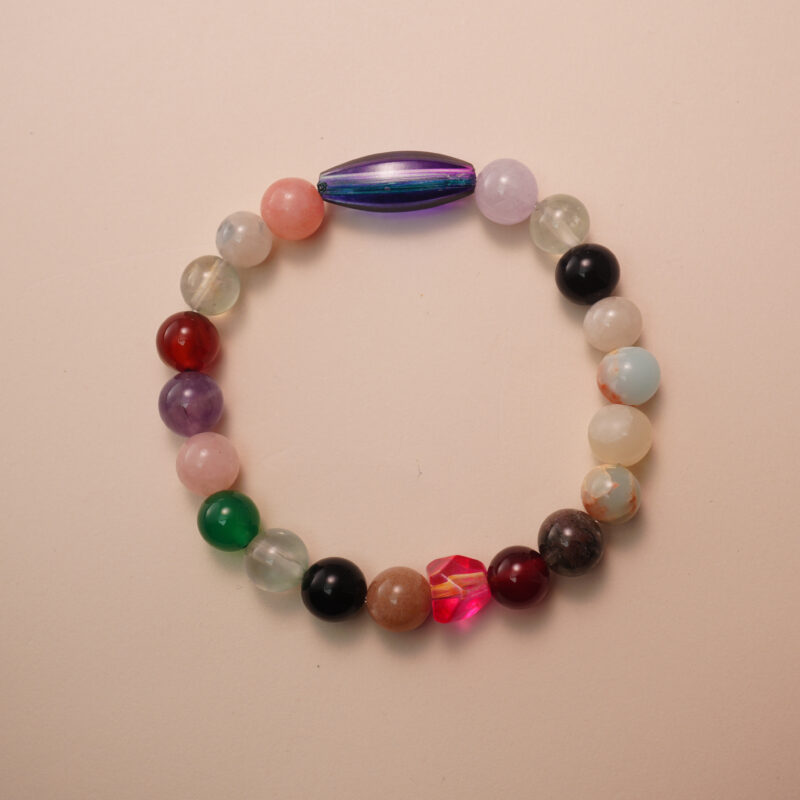Multicolor crystal healing bracelet made with assorted gemstones, photographed under soft daylight on a neutral background.