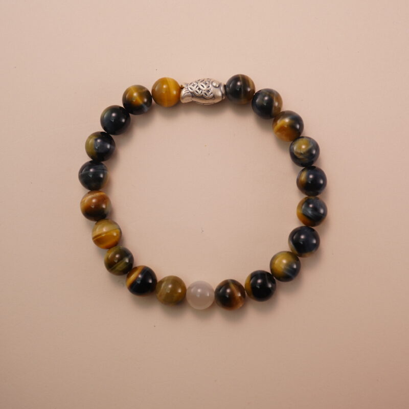 Tiger’s eye and white chalcedony bracelet with a silver fish accent bead, photographed under soft daylight to highlight the natural golden and creamy tones of the gemstones.