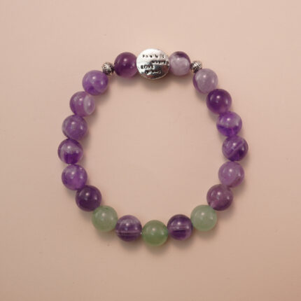 Amethyst and prehnite bracelet with a silver accent bead, photographed under soft daylight to highlight the calming purple and gentle green tones.