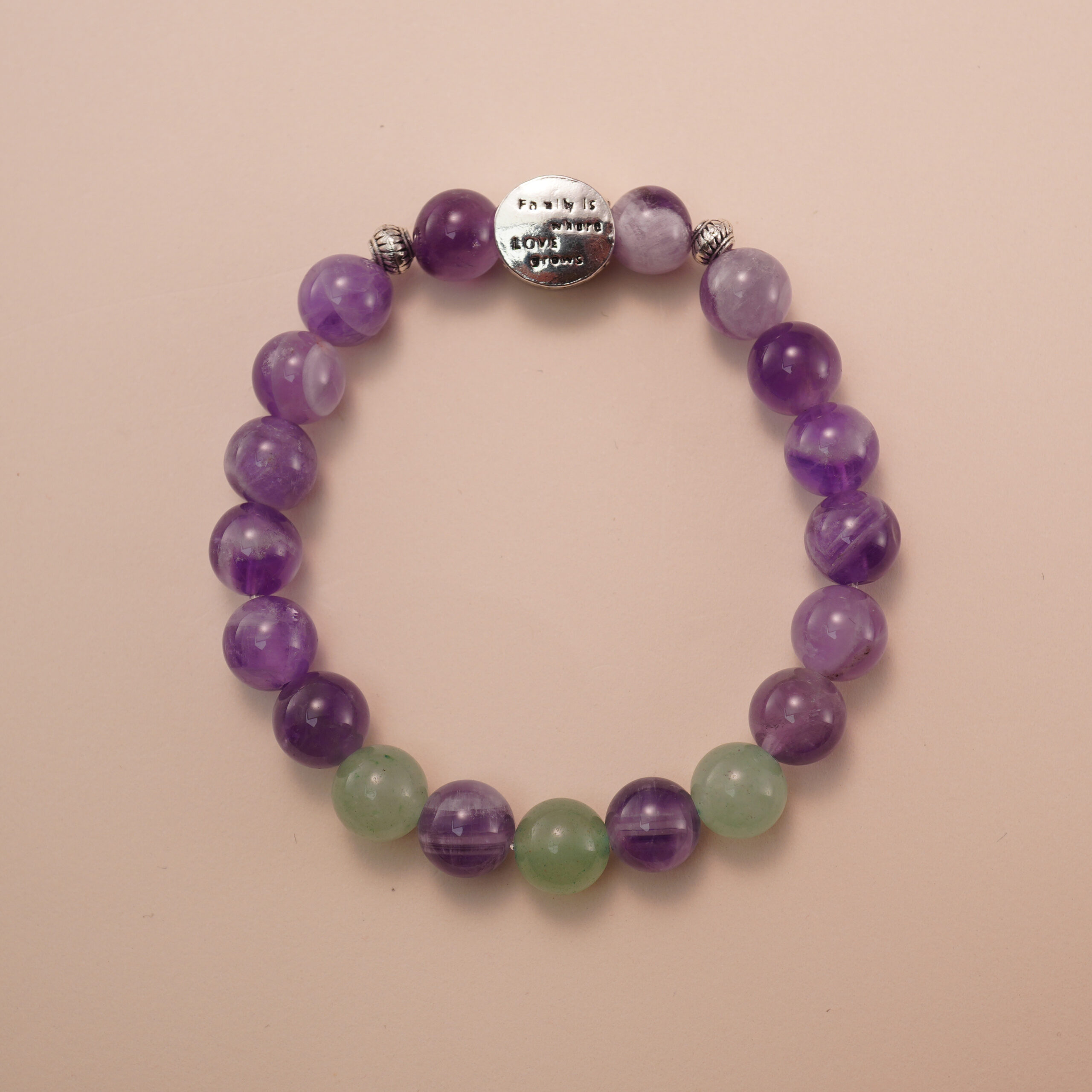 amethyst-prehnite-bracelet-with-silver-bead Amethyst and prehnite bracelet with a silver accent bead, photographed under soft daylight to highlight the calming purple and gentle green tones.