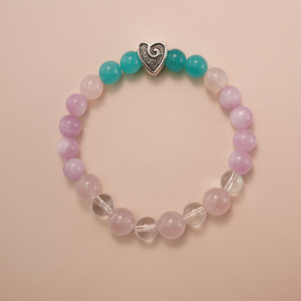 Kunzite, amazonite, and clear quartz bracelet with a silver heart accent bead, photographed under soft daylight to highlight the pastel purple, aqua green, and translucent white tones.