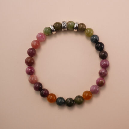Multicolor tourmaline bracelet photographed under soft daylight on a neutral background, showing the natural gradient of pink, green, and brown gemstones.