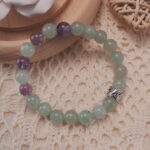 Prehnite and amethyst bracelet shown in a lifestyle setting under natural light, highlighting its calming green and purple tones.