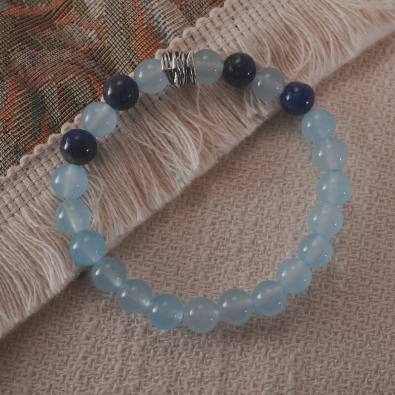 Aquamarine and lapis lazuli bracelet displayed in a natural lifestyle setting under soft daylight, highlighting the contrast between light blue and deep navy hues.