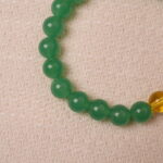 Detailed view of green aventurine and citrine bracelet, emphasizing the smooth polish and harmony.