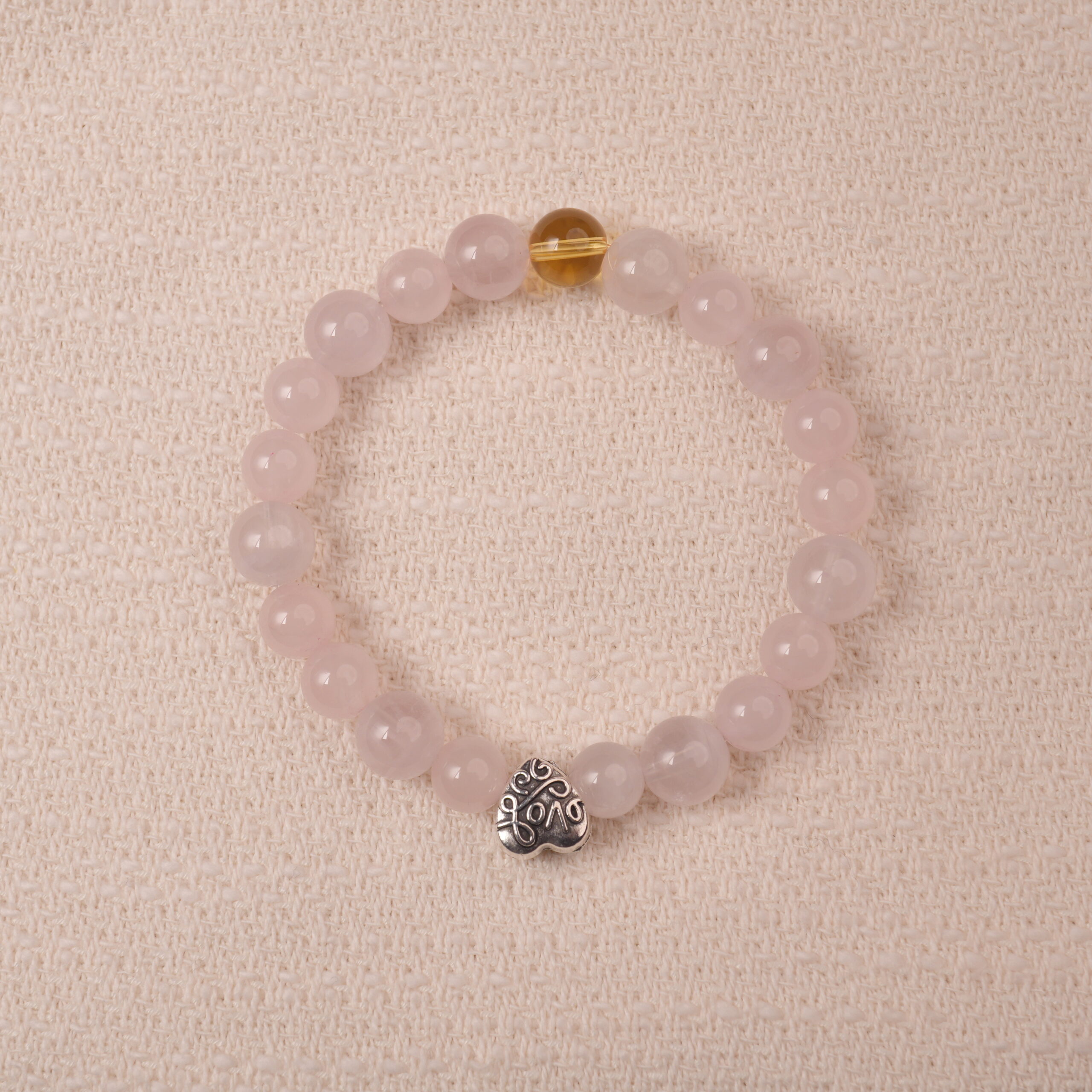 rose-quartz-citrine-heart-bracelet-main.jpg Rose quartz and citrine bracelet with silver heart charm, symbolizing love, happiness, and gentle energy.