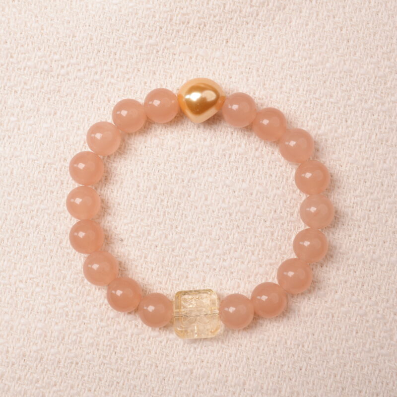 Peach moonstone bracelet with citrine and gold heart bead, symbolizing love, abundance, and gentle feminine energy.
