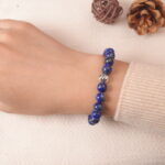 Model wearing lapis lazuli and clear quartz bracelet, showing elegant blue gemstone balance.