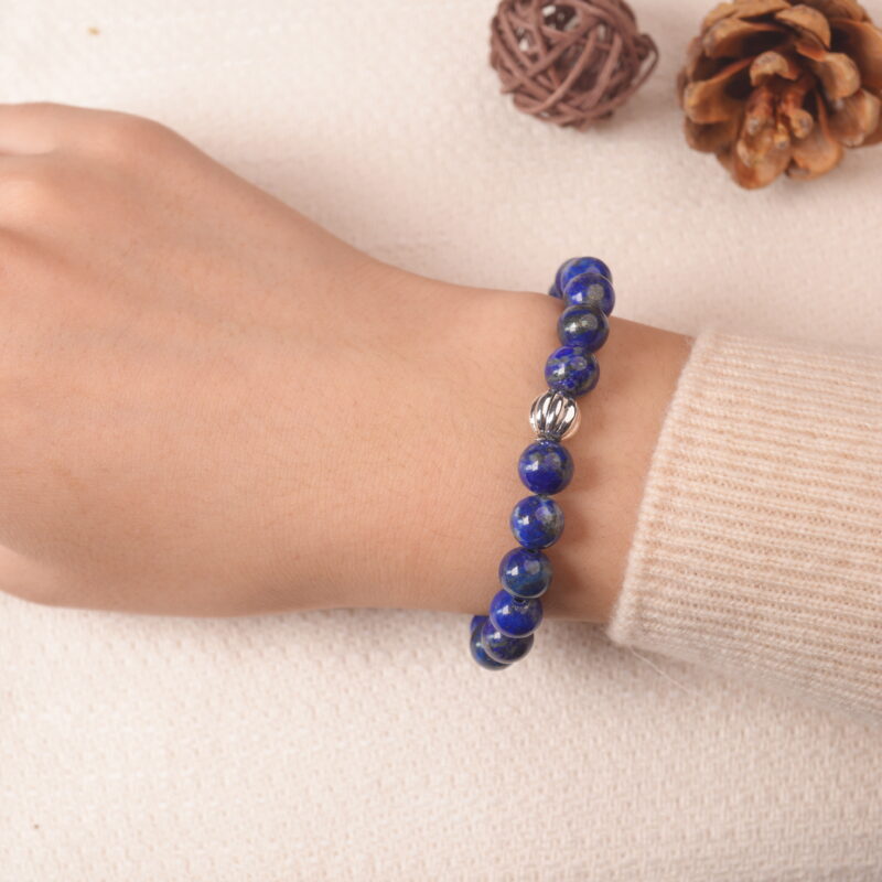 Model wearing lapis lazuli and clear quartz bracelet, showing elegant blue gemstone balance.